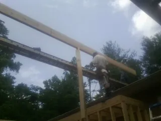 Carpenter setting a ridge beam over a new addition frame — Ice Dam Removal by Roofing Brothers in Costa Mesa