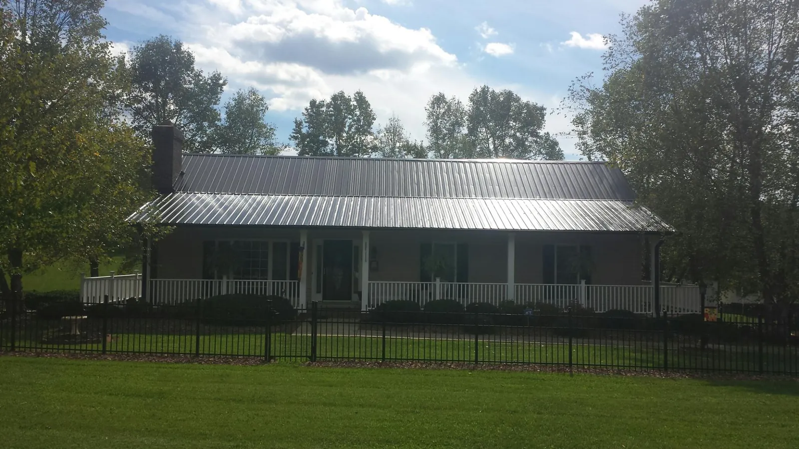 Gray metal roof on a brick ranch with a full width front porch — Gutter Guard Installation work by our crew in Costa Mesa