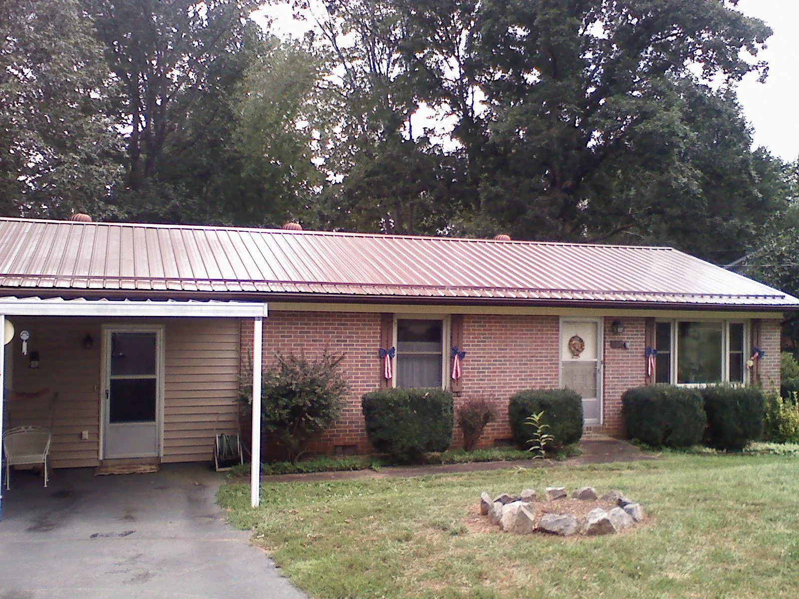Bronze metal roof and carport on a brick ranch home — Roof Repair work by our crew in Costa Mesa